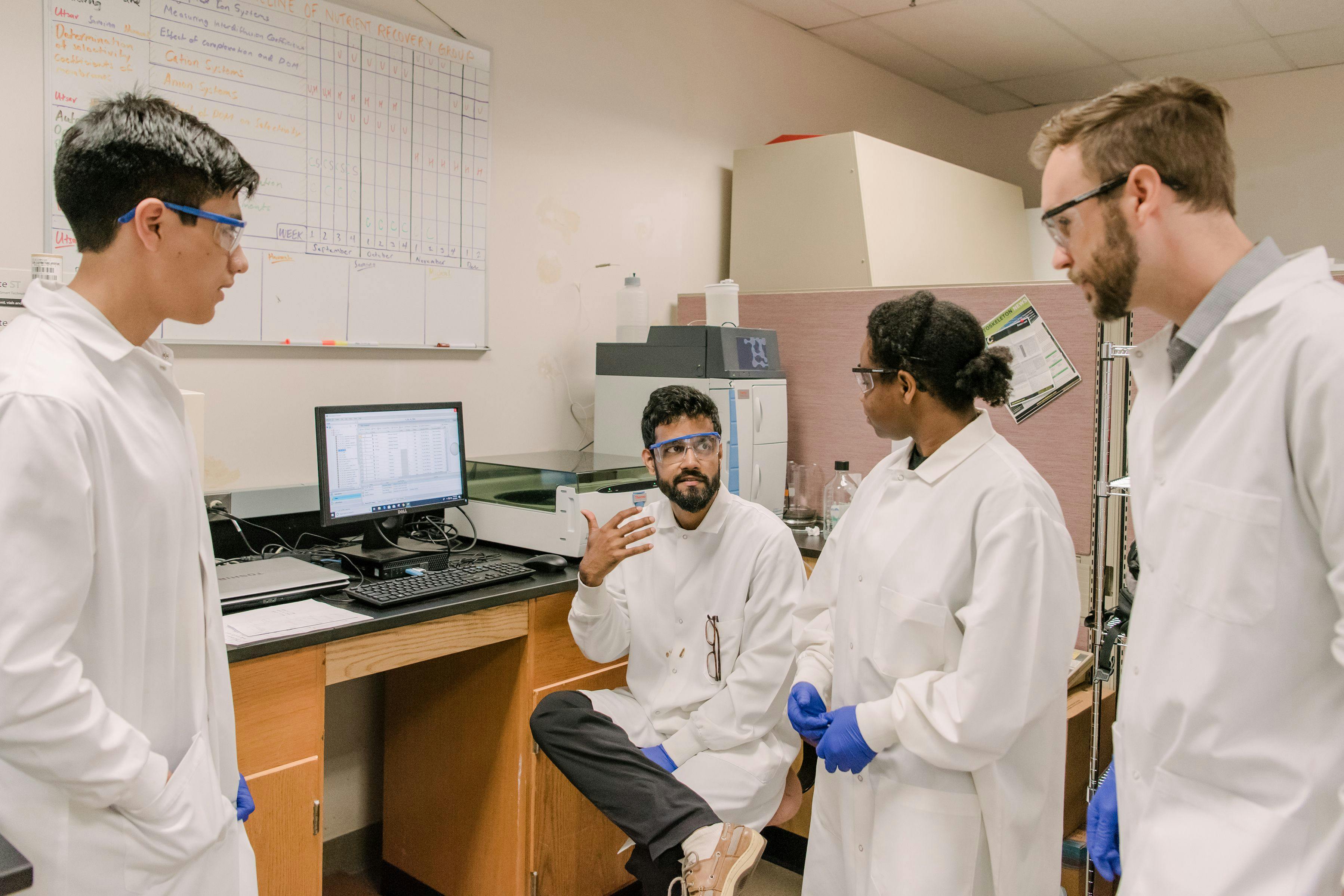 Blaney (right) with undergraduate researchers Fabian Amurrio (left) and Lauren Harris (second from right) and PhD candidate Utsav Shashvatt (second from left) discuss ion chromatography results related to a project focused on nutrient recovery from waste streams. | Photo Credit: © Lee Blaney