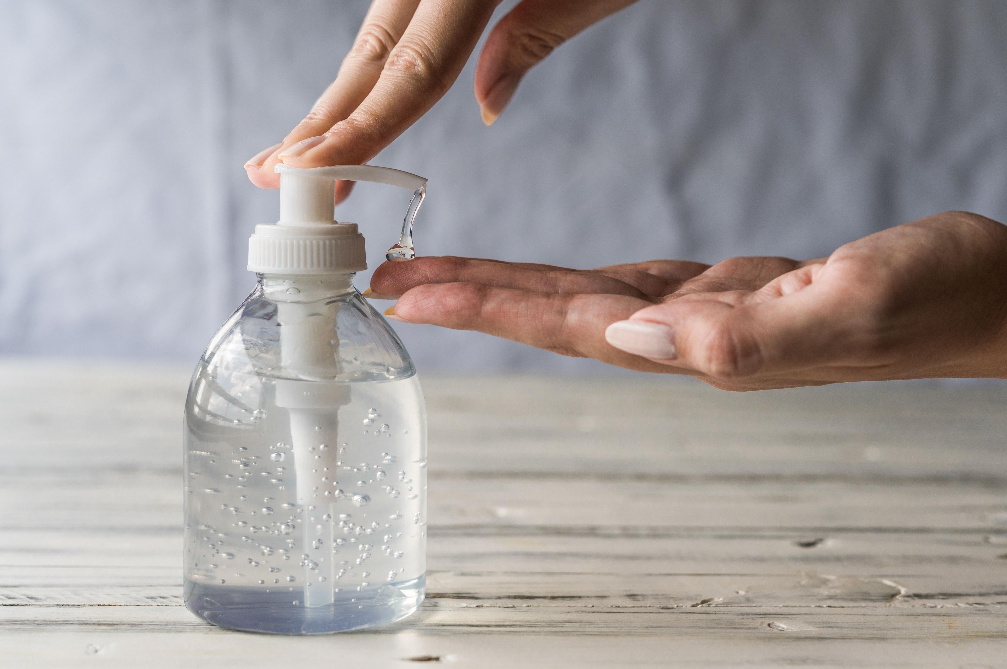 Young woman using hand sanitizer gel with liquid alcohol disinfectant for prevention of coronavirus and other pandemic and epidemic diseases. © Aleksander Vorobev - stock.adobe.com