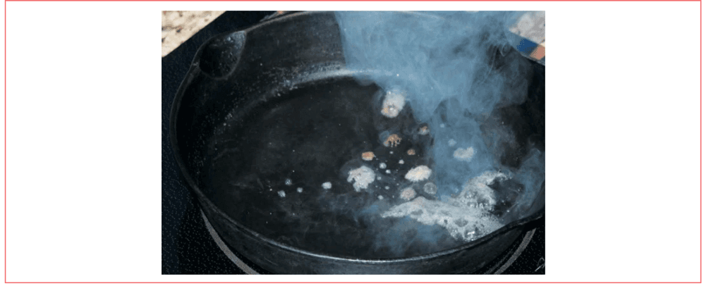 Figure 2: Result of about 1 teaspoon of water being added to a cast iron skillet. Full evaporation required appromixately 10 s. Note that some droplets are colored due to contamination on the skillet surface. Reprinted from reference (4) with permission of the author.