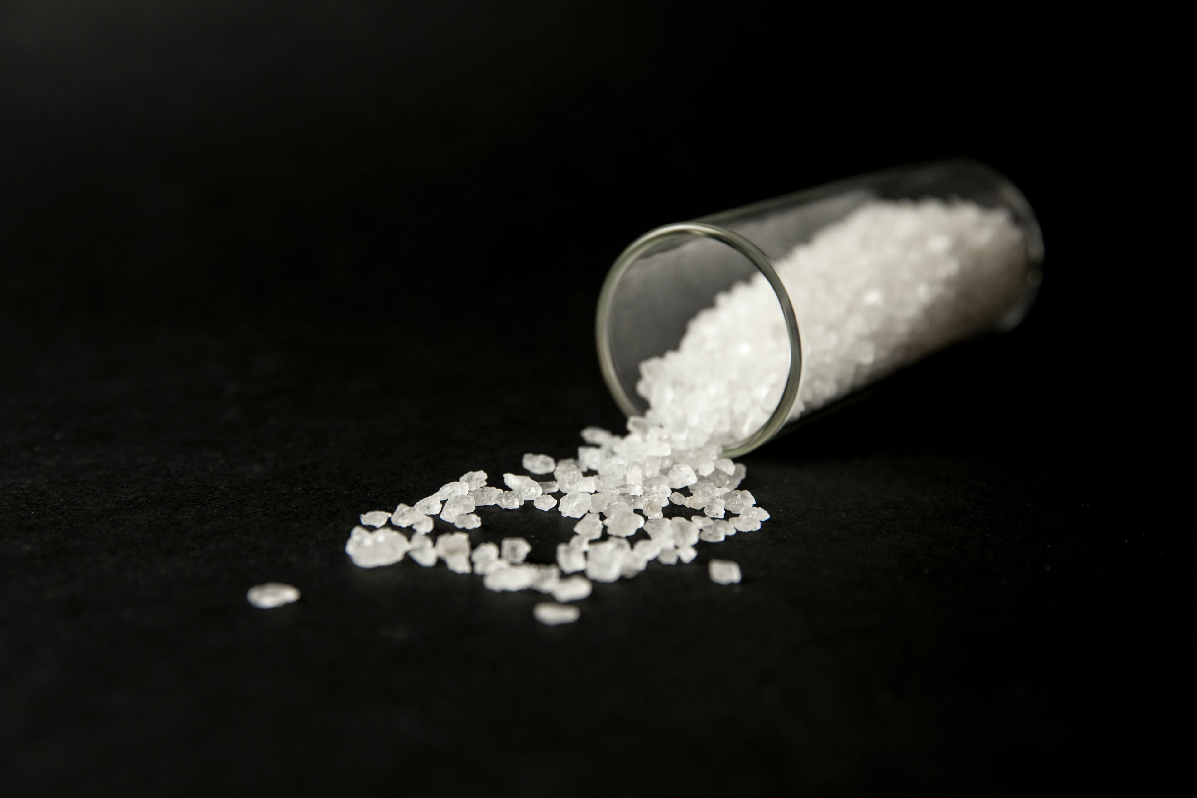 Conceptual image of "bath salts" synthetic cathinones drugs narcotics concept. White crystal powder on black background( set up), resemble to bathroom bath salt. | Image Credit: © FotoHelin - stock.adobe.com.