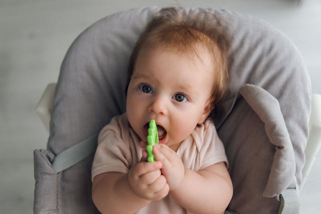 Cute close-up of baby lying in cradle and holding teething ring, adorable baby 5 month old baby | Image Credit: © Katrin_Primak - stock.adobe.com