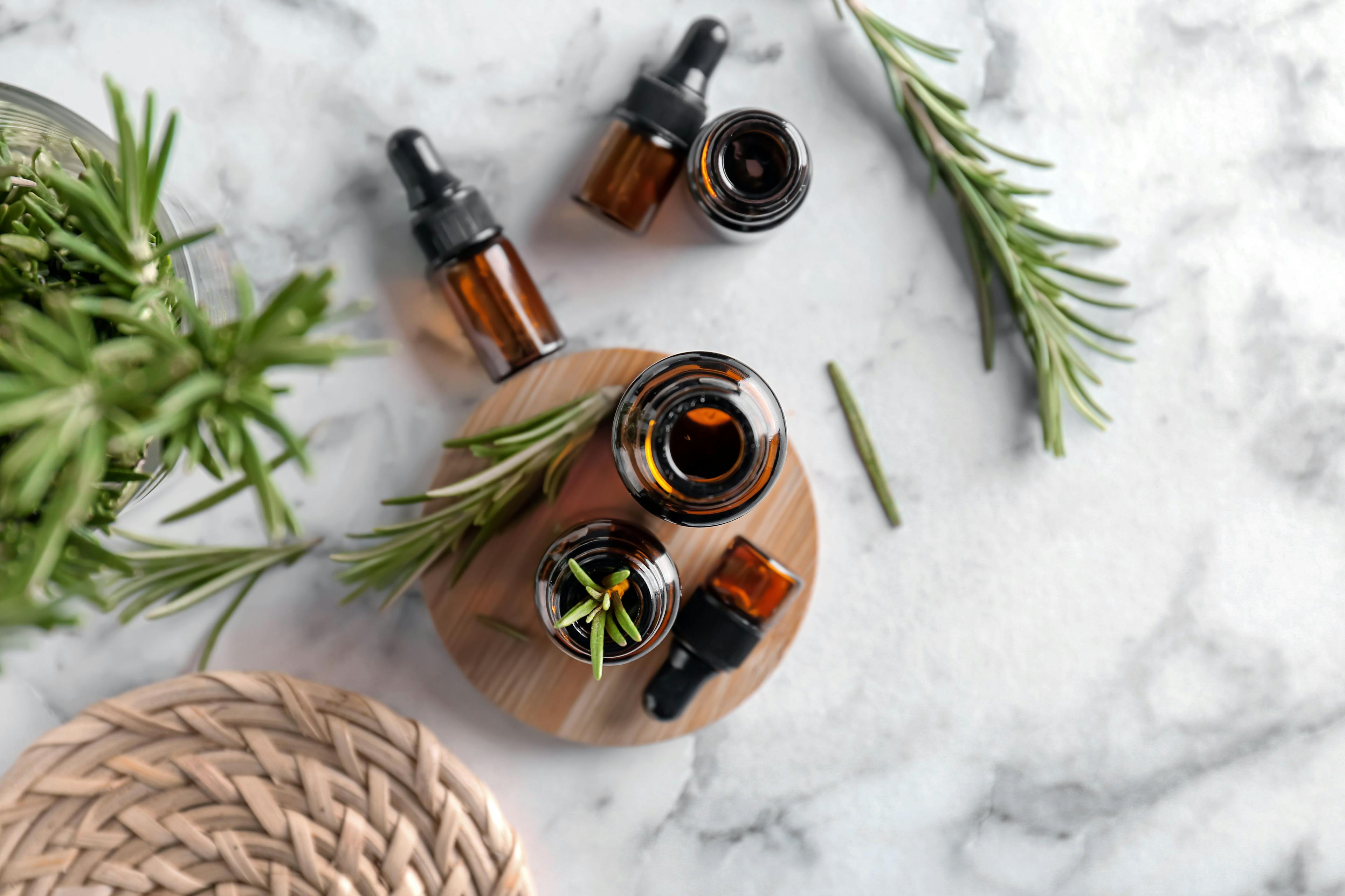 Bottles with rosemary essential oil on light background, top view | Image Credit: © New Africa - stock.adobe.com