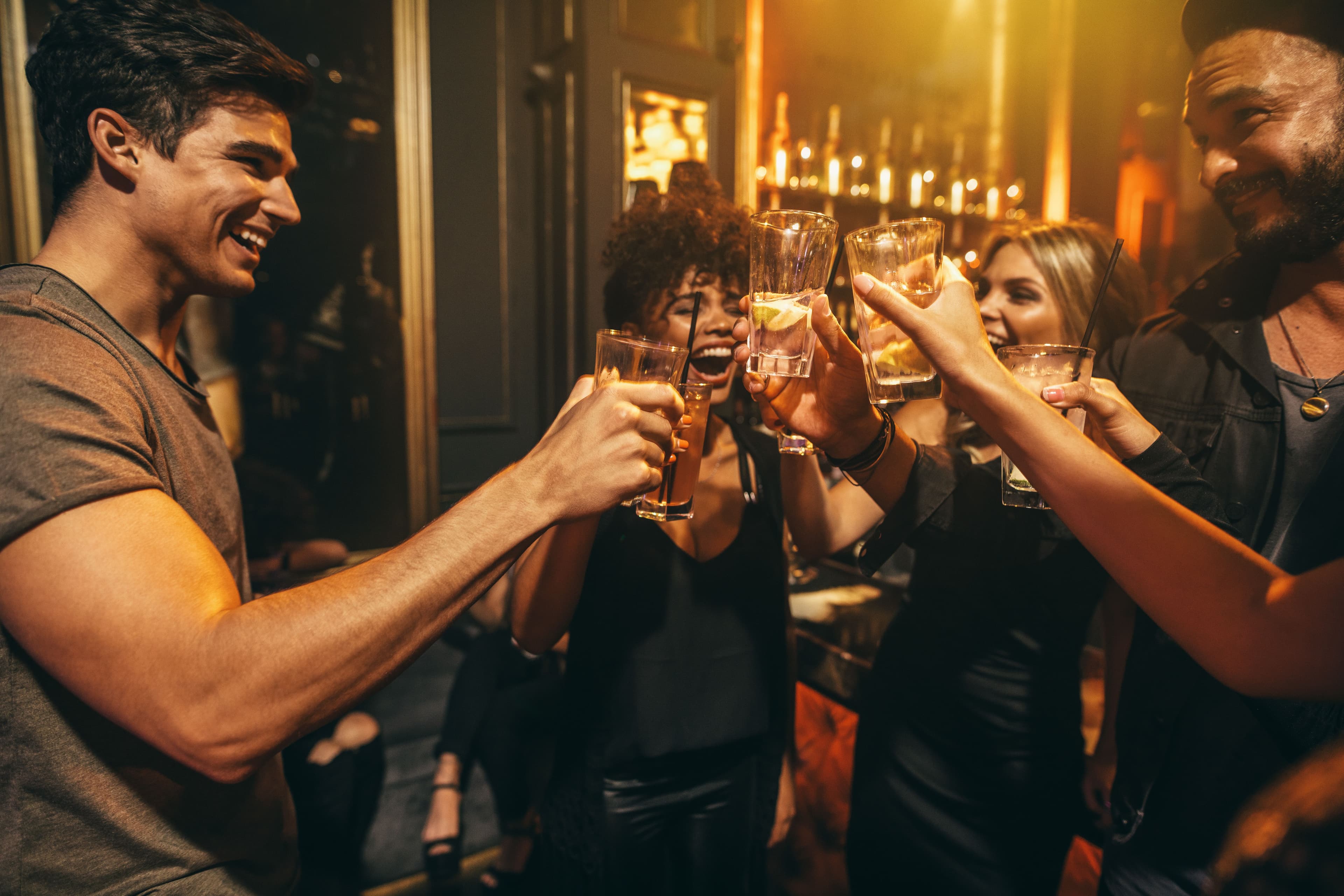 Group of men and women enjoying drinks at nightclub. © Jacob Lund - stock.adobe.com